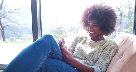 Image showing african american woman at home using digital tablet