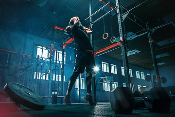 Image showing Fit young man lifting barbells working out in a gym