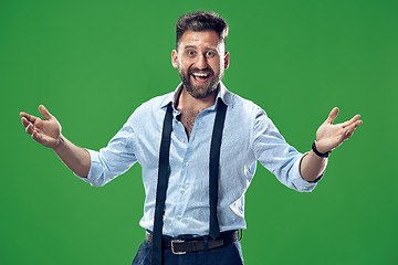 Image showing The happy business man standing and smiling against green background.