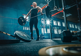 Image showing Fit young woman lifting barbells working out in a gym