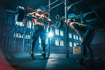 Image showing Fit young man lifting barbells working out in a gym