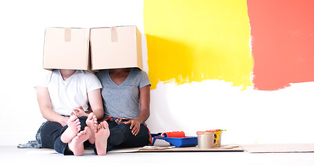 Image showing young multiethnic couple playing with cardboard boxes