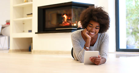 Image showing black women using tablet computer on the floor