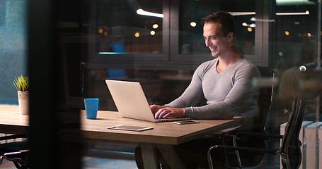 Image showing man working on laptop in dark office