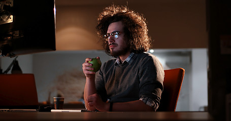 Image showing man working on computer in dark office