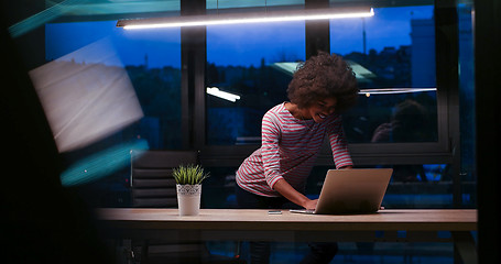 Image showing black businesswoman using a laptop in night startup office