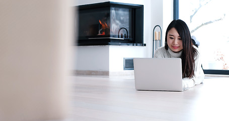 Image showing Asian woman using laptop on floor