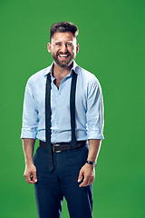 Image showing The happy business man standing and smiling against green background.