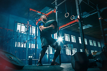 Image showing Fit young man lifting barbells working out in a gym