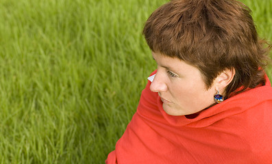 Image showing  redhead woman sitting on the grass