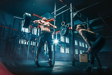 Image showing Fit young man lifting barbells working out in a gym