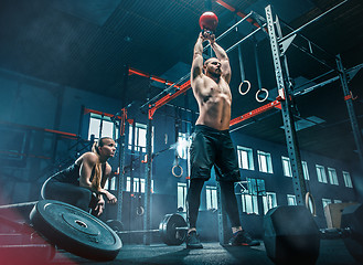 Image showing Fit young man lifting barbells working out in a gym