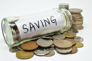 Image showing Saving lable in a glass jar with coins spilling out