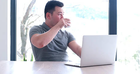 Image showing businessman working using a laptop in startup office