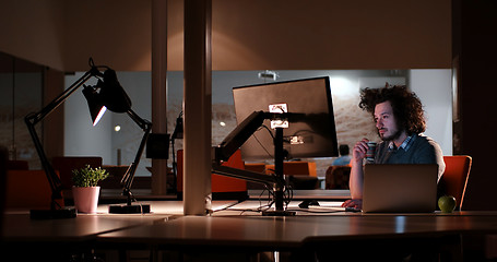 Image showing man working on computer in dark office