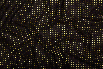 Image showing Crumpled black fabric with golden metallic dots