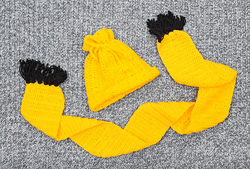 Image showing Yellow knitted hat and scarf on gray wool background