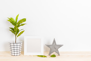 Image showing Home decor with picture frame, concrete star and plant