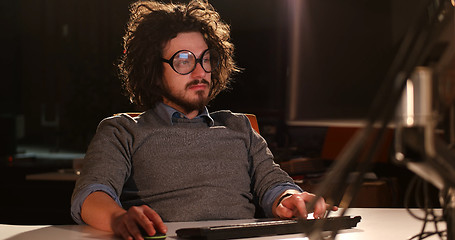 Image showing man working on computer in dark office