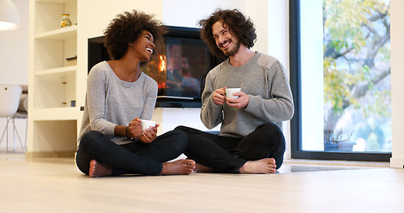 Image showing multiethnic couple  in front of fireplace