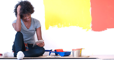 Image showing black female painter sitting on floor