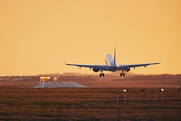 Image showing Airplane landing at sunset