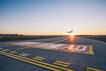 Image showing Airplane landing at sunset