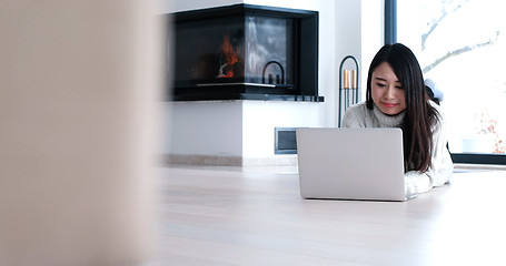 Image showing Asian woman using laptop on floor