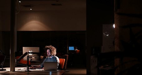 Image showing man working on computer in dark office