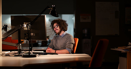 Image showing man working on computer in dark office