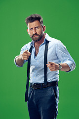 Image showing The overbearing businessman point you and want you, half length closeup portrait on green background.