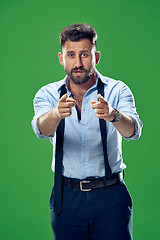 Image showing The overbearing businessman point you and want you, half length closeup portrait on green background.