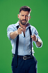 Image showing The overbearing businessman point you and want you, half length closeup portrait on green background.