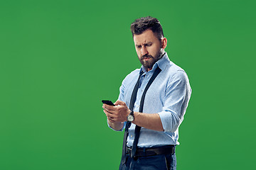 Image showing Handsome businessman checking emails on the phone