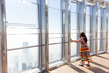 Image showing Female tourists having fear of heigh at the top the observation deck of the highest building in the world,Burj Khalifa in Dubai, UAE.