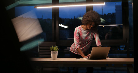 Image showing black businesswoman using a laptop in night startup office