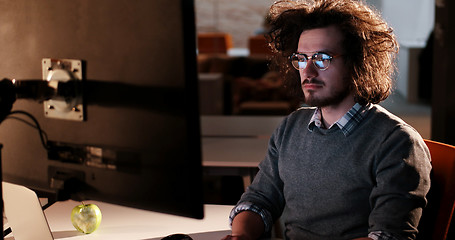 Image showing man working on computer in dark office