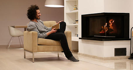 Image showing young man at home reading book