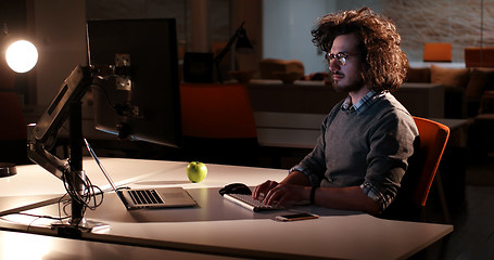 Image showing man working on computer in dark office