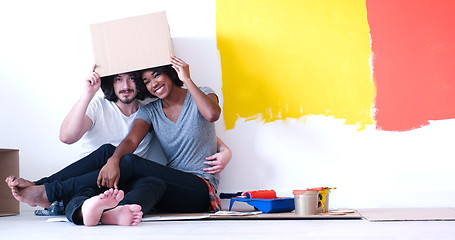 Image showing young multiethnic couple playing with cardboard boxes