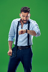 Image showing Handsome businessman checking his wrist-watch Isolated on white background