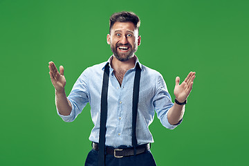 Image showing The young attractive man looking suprised isolated on green