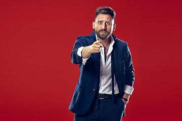 Image showing The overbearing businessman point you and want you, half length closeup portrait on red background.