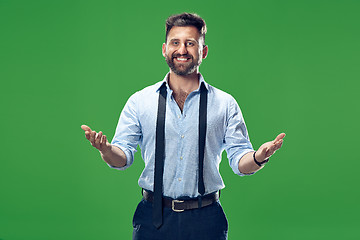 Image showing The young attractive man looking suprised isolated on green