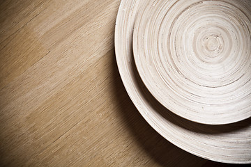 Image showing Two bamboo bowls on wooden background.