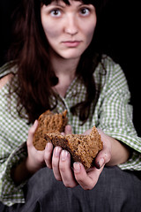 Image showing Poor beggar woman with a piece of bread.
