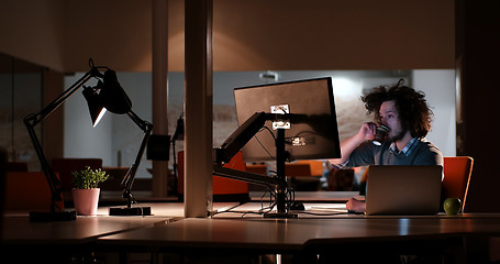 Image showing man working on computer in dark office