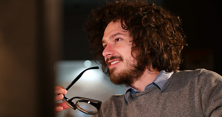 Image showing man working on computer in dark office