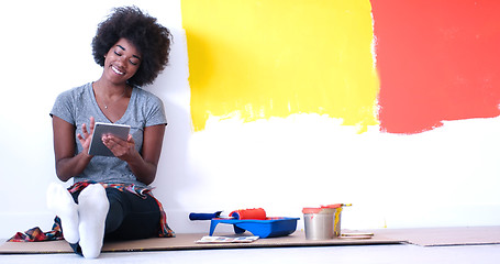 Image showing black female painter sitting on floor