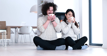 Image showing multiethnic romantic couple  in front of fireplace